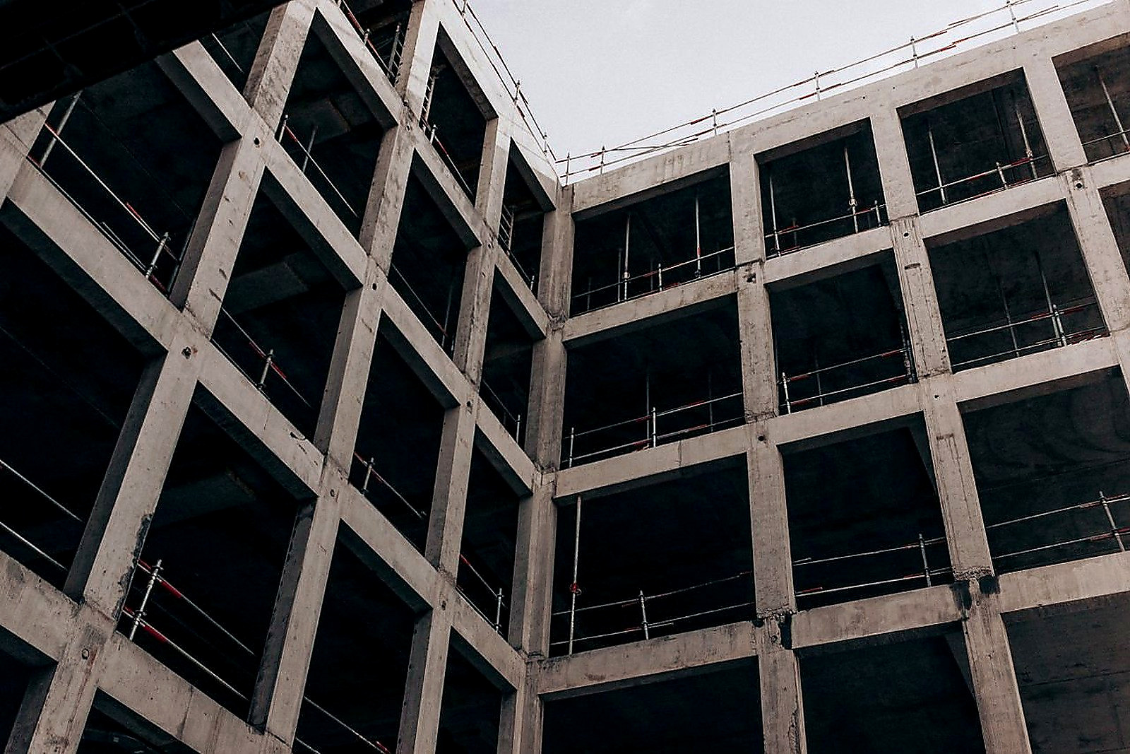 Free A low angle view of a modern concrete building under construction, showcasing its structure and design. Stock Photo